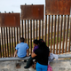 A family looks towards metal bars marking the United States border in Tijuana, Mexico. (AP Photo/Gregory Bull)